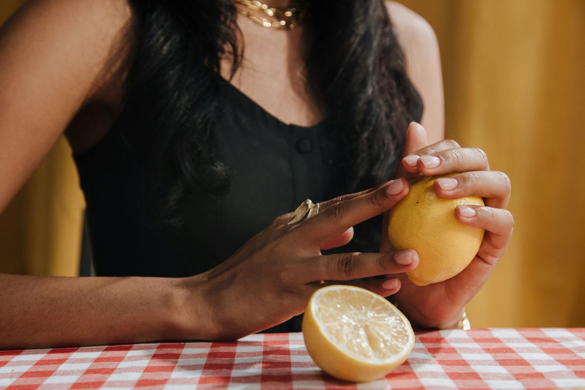 Close-up of a woman holding a fresh lemon, representing the citrus-inspired design of lemon vibrators.