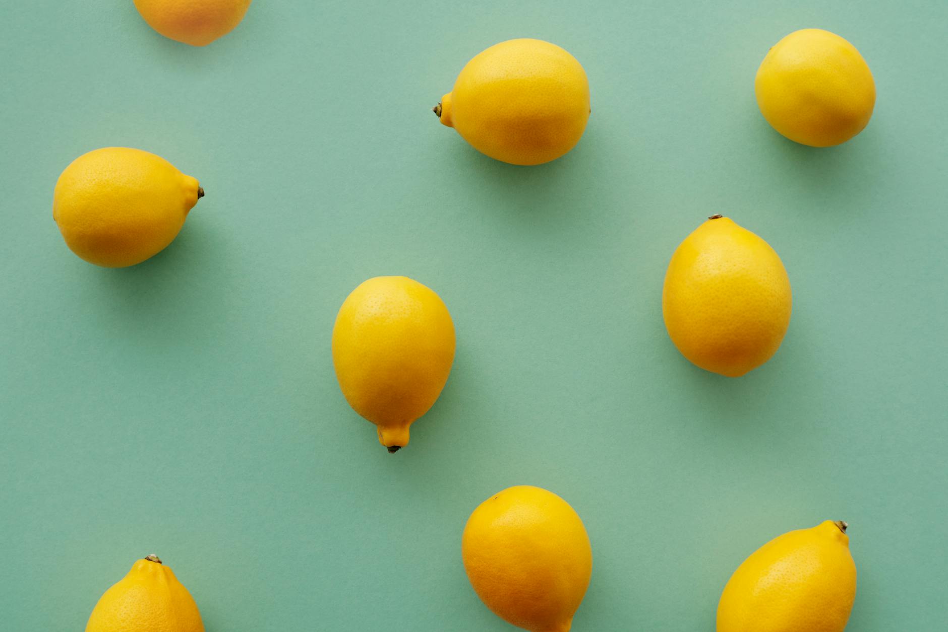 Bright yellow lemons on a pastel green background, symbolizing the cyclical changes in pleasure throughout the month