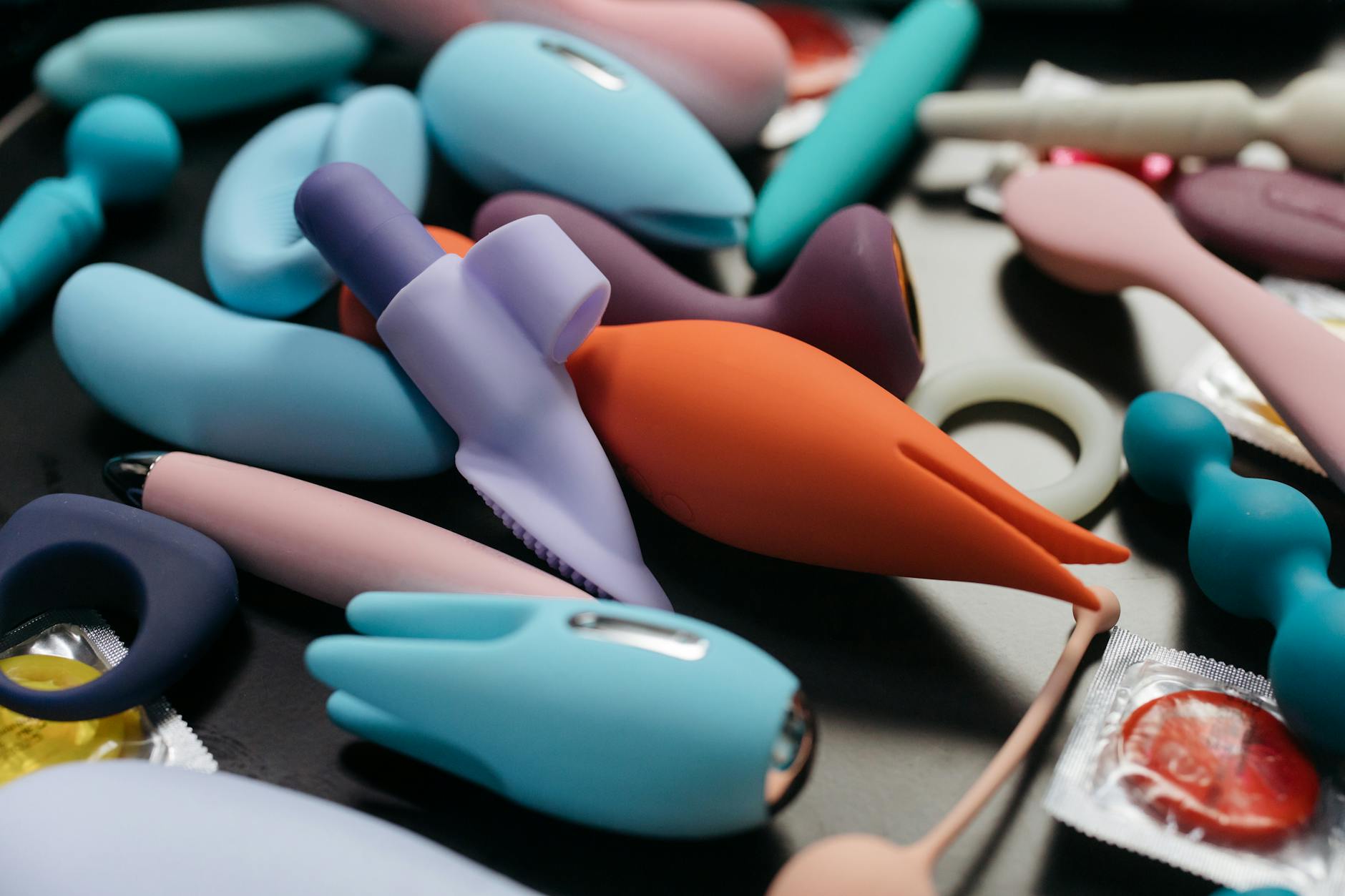 Close-up of hands holding a blue personal massager against a knitted sweater