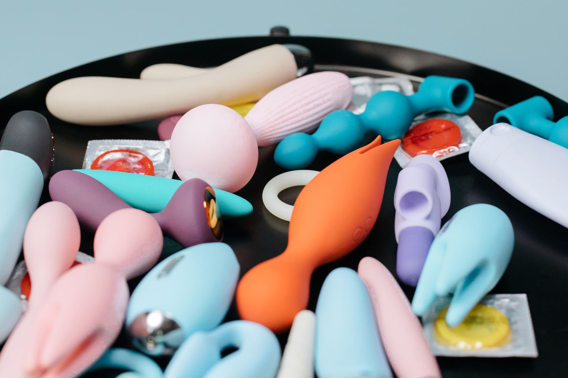 A blue silicone clitoral vibrator held in hand, representing accessible pleasure and sexual wellness