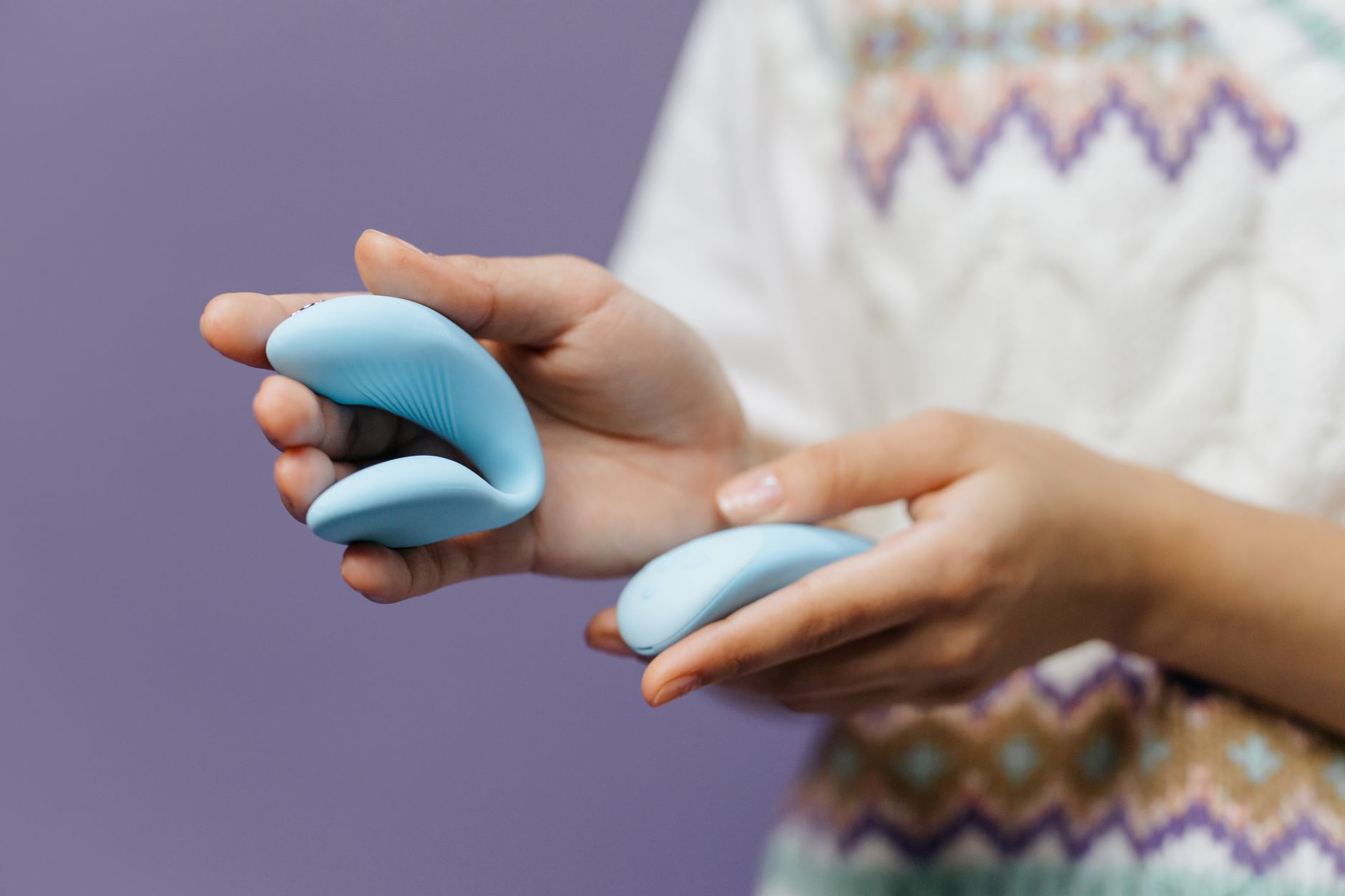 Woman holding a sleek blue vibrator, symbolizing personal pleasure and autonomy in intimate relationships.