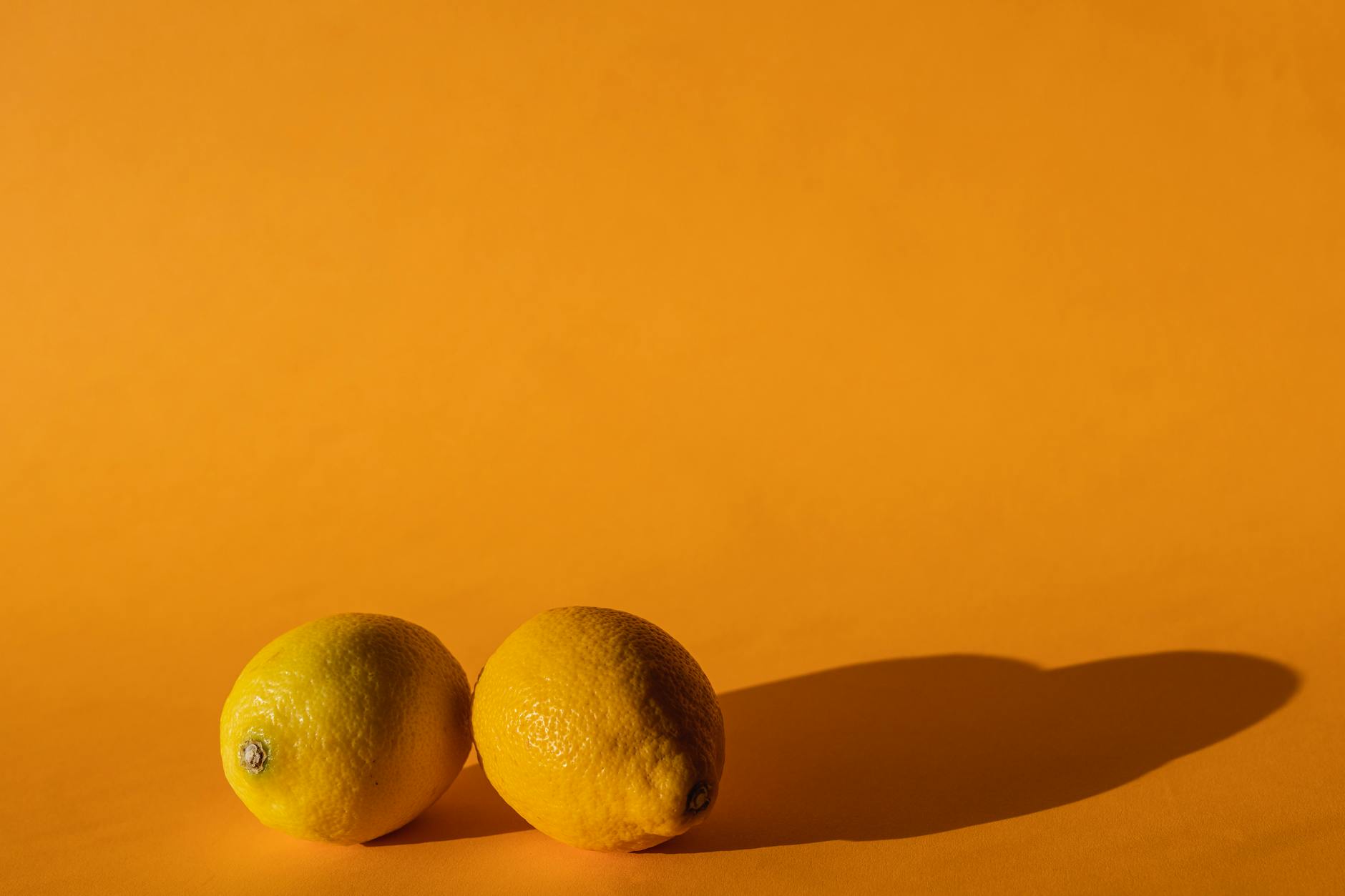 Ripe vivid lemons composed on yellow background in bright daylight
